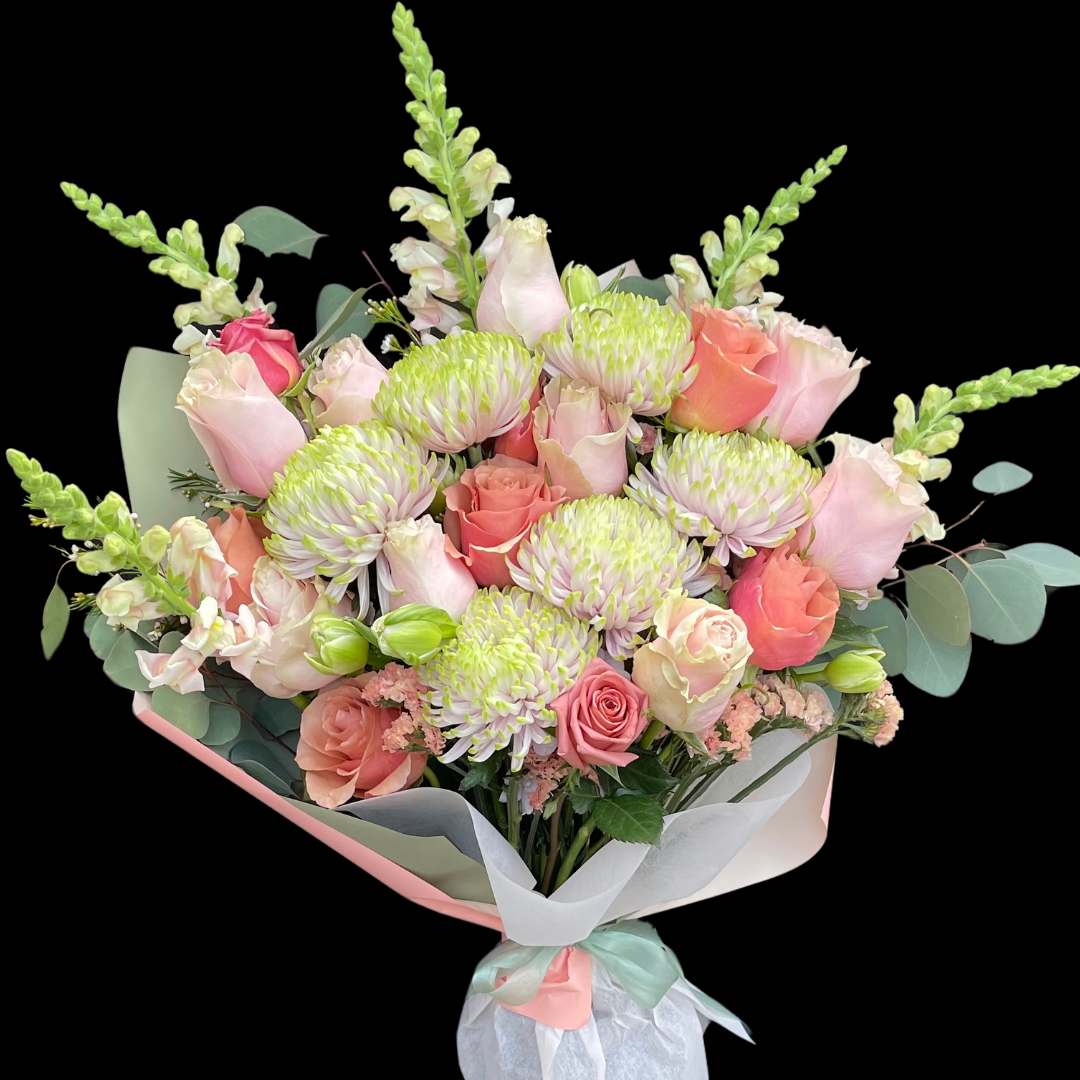 A hand-tied birthday bouquet with a variety of flowers including roses, chrysanthemum and seasonal blooms.